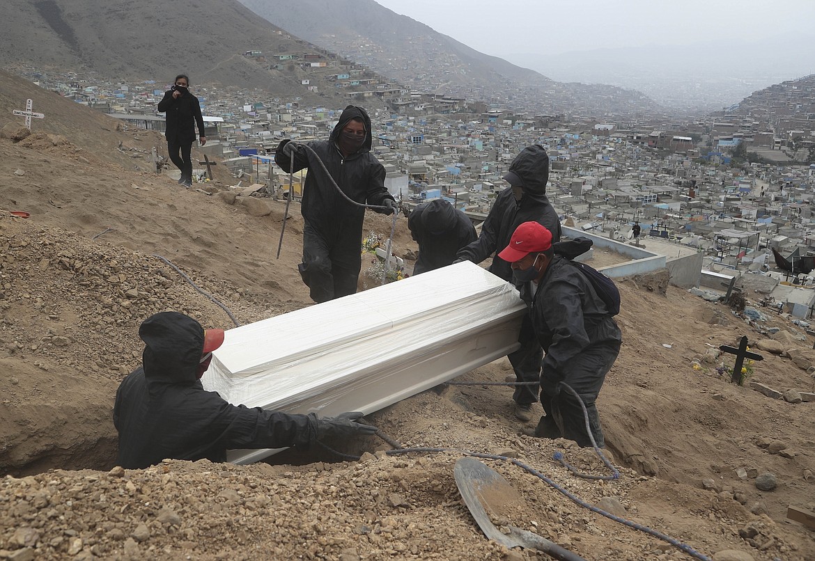 FILE - In this Wednesday, June 17, 2020 file photo Cemetery workers place into a grave the coffin that contains the remains Juliana Ramos at the Martires 19 de Julio cemetery, on the outskirts of Lima, Peru. (AP Photo/Martin Mejia, File)