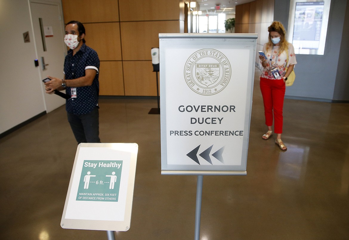 Members of the media wait to be escorted to a briefing room to hear Arizona Republican Gov. Doug Ducey speak about the latest Arizona coronavirus data at a news conference Thursday, June 25, 2020, in Phoenix. (AP Photo/Ross D. Franklin, Pool)