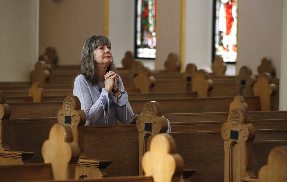 Due to the coronavirus, a parishioner prays during a modest and shortened service at St. Mary's Roman Catholic Basilica Sunday, March 22, 2020, in Phoenix. (AP Photo/Ross D. Franklin)