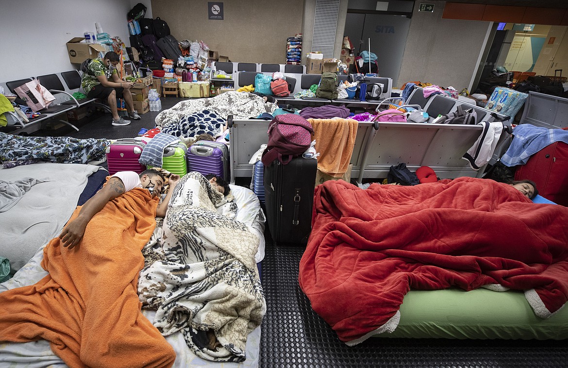 Stranded Colombians sleep inside the Sao Paulo international airport while flights are severely limited during the COVID-19 pandemic in Guarulhos, Brazil, Wednesday, May 27, 2020. Hundreds of people, including migrants who have lost their jobs and tourists, have been living inside the airport, waiting for humanitarian flights to leave Brazil. (AP Photo/Andre Penner)