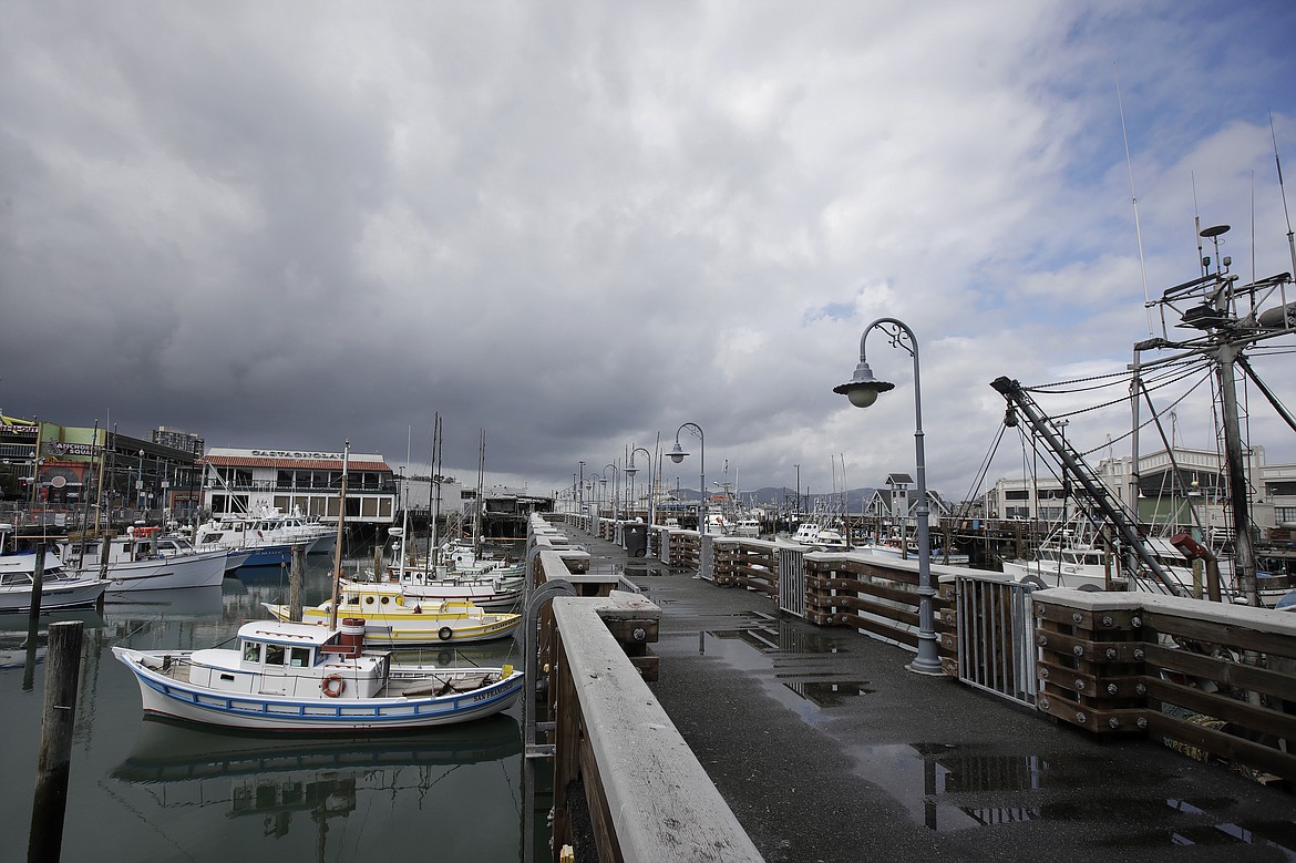 Boats are shown docked in a nearly empty Fisherman's Wharf area of San Francisco, Sunday, March 29, 2020. (AP Photo/Jeff Chiu)