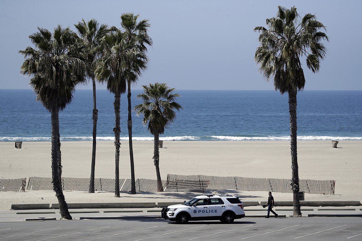 Police patrol the closed-off Santa Monica beach Sunday, March 29, 2020, in Los Angeles. With cases of coronavirus surging and the death toll increasing, lawmakers are pleading with cooped-up Californians to spend a second weekend at home to slow the spread of the infections. (AP Photo/Marcio Jose Sanchez)