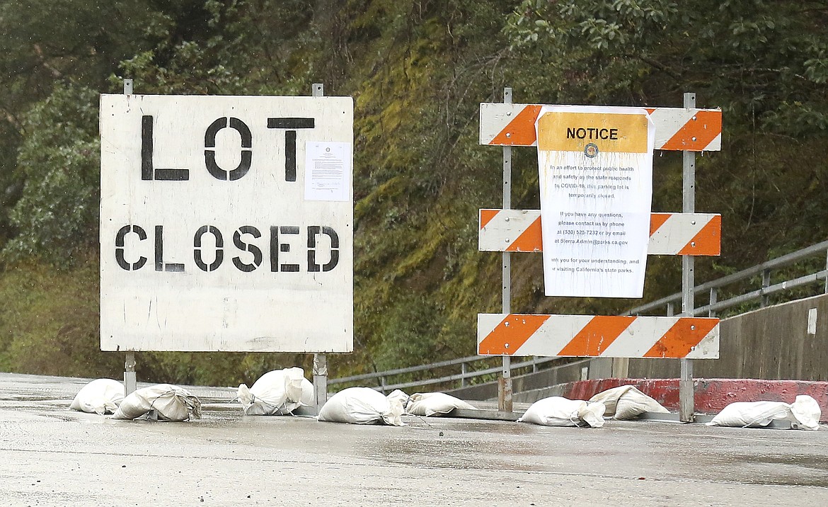 Signage lets people know of the Sierra District California State Park parking lot closures in Nevada City intended to help discourage large groups of people gathering in high traffic places due to the coronavirus, Saturday, March 28, 2020.  (Elias Funez/The Union via AP)