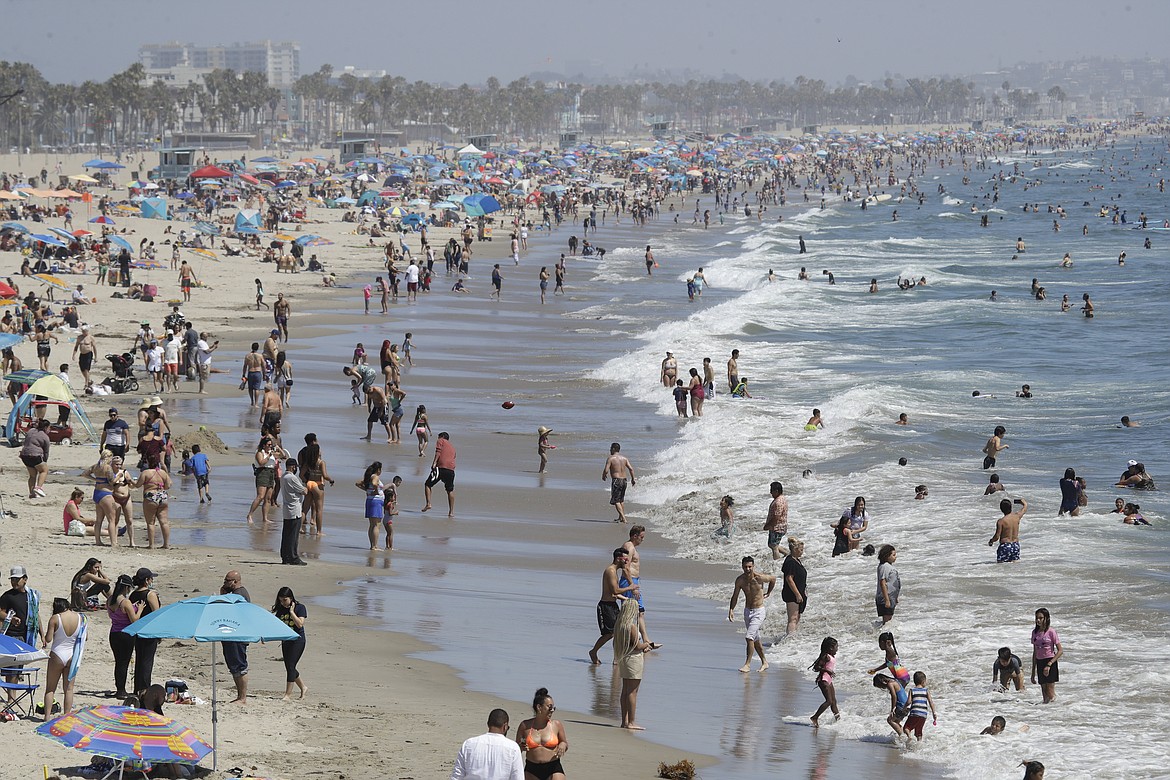 Visitors crowd the beach Sunday, July 12, 2020, in Santa Monica, Calif., amid the coronavirus pandemic. A heat wave has brought crowds to California's beaches as the state grappled with a spike in coronavirus infections and hospitalizations. (AP Photo/Marcio Jose Sanchez)