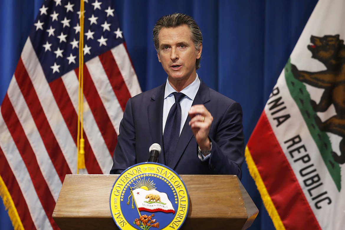 FILE - In this Thursday, May 14, 2020, file photo California Gov. Gavin Newsom discusses his revised 2020-2021 state budget during a news conference in Sacramento, Calif. Gov. Newsom signed a $202.1 billion state budget Monday, June 29, in Sacramento, Calif. The budget closes an estimated $54.3 billion deficit through a combination of spending cuts, internal borrowing and temporary tax increases on businesses. Like most states, California's deficit was driven by the economic downturn caused by the coronavirus. (AP Photo/Rich Pedroncelli, Pool, File)