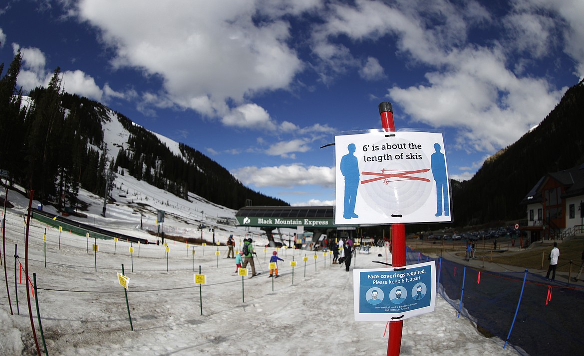 Signs stand at the lines to the lift at the reopening of Arapahoe Basin Ski Resort, which closed in mid-March to help in the effort to stop the spread of the new coronavirus, Wednesday, May 27, 2020, in Keystone, Colo. The ski area is the only one in the state to take advantage of the relaxation of coronavirus restrictions by Colorado. (AP Photo/David Zalubowski)