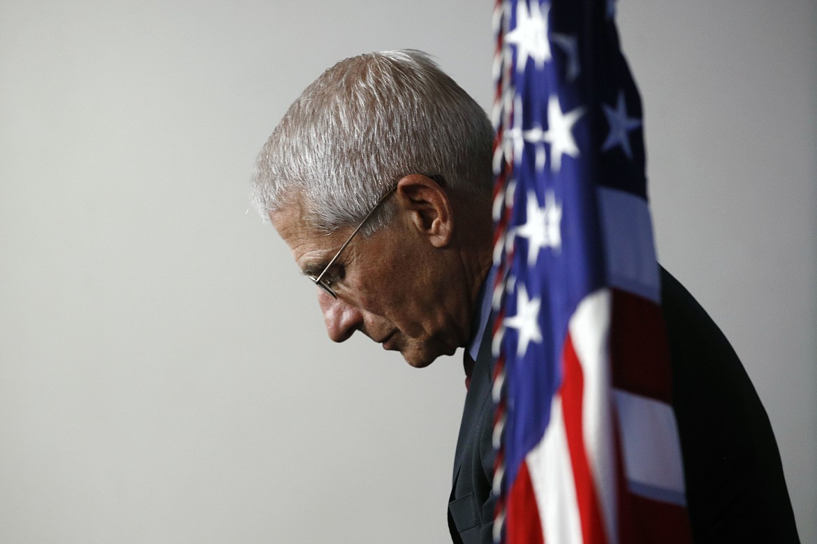 FILE - In this April 4, 2020 file photo, Dr. Anthony Fauci, director of the National Institute of Allergy and Infectious Diseases, listens as President Donald Trump speaks during a coronavirus task force briefing at the White House in Washington. (AP Photo/Patrick Semansky)