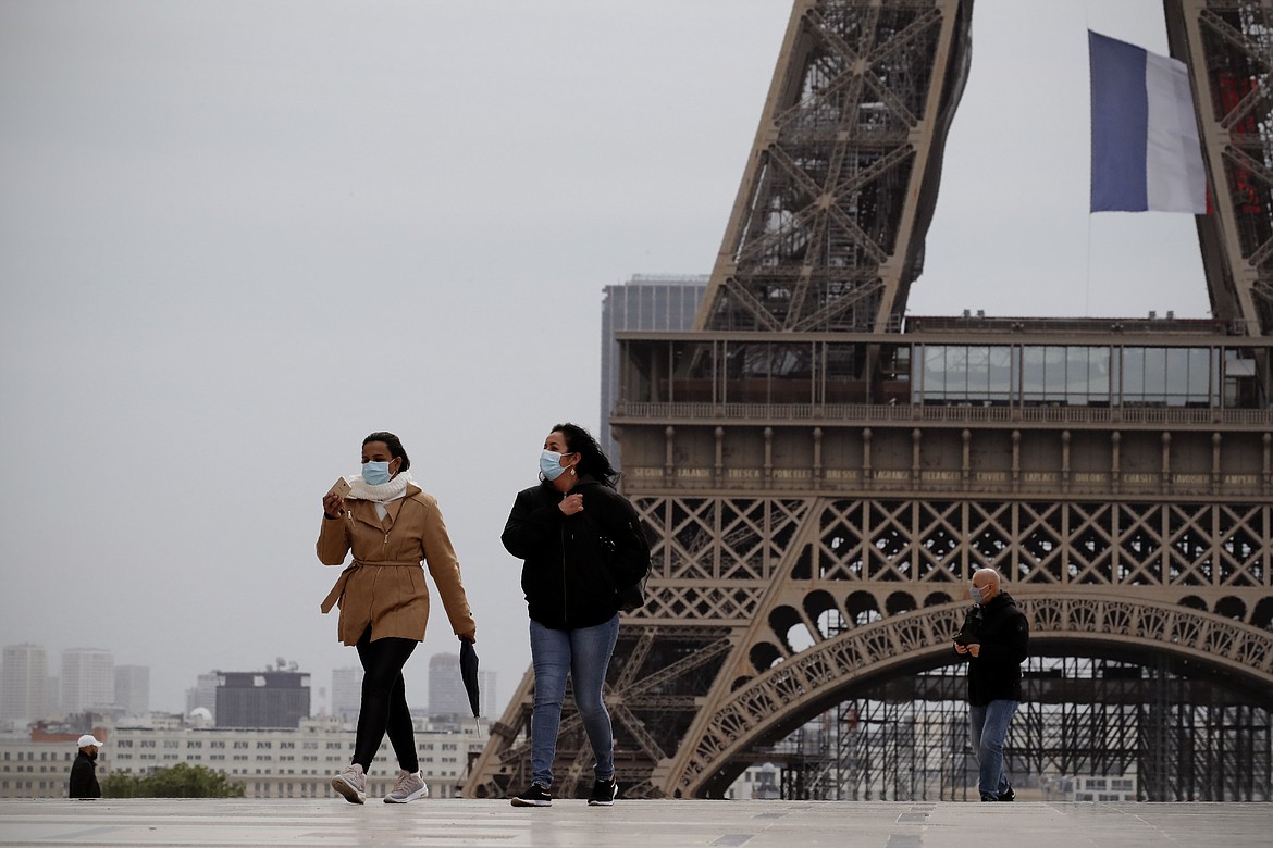 People walk near the Eiffel Tower, in Paris, Monday, May 11, 2020. The French began leaving their homes and apartments for the first time in two months without permission slips as the country cautiously lifted its lockdown. Clothing stores, coiffures and other businesses large and small were reopening on Monday with strict precautions to keep the coronavirus at bay. (AP Photo/Christophe Ena)