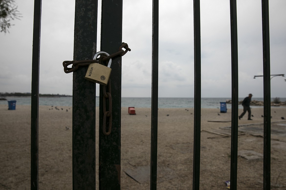 A padlock is seen on the entrance of a beach at Alimos suburb of Athens, Sunday, March 22, 2020. Schools, restaurants, and other public places are already closed in the Greek capital aimed at slowing the spread of the new coronavirus, but other places like supermarkets, pharmacies and gas stations remain open.  The COVID-19 illness causes mild or moderate symptoms in most people, but severe symptoms are more likely in the elderly or those with existing health problems. (AP Photo/Yorgos Karahalis)