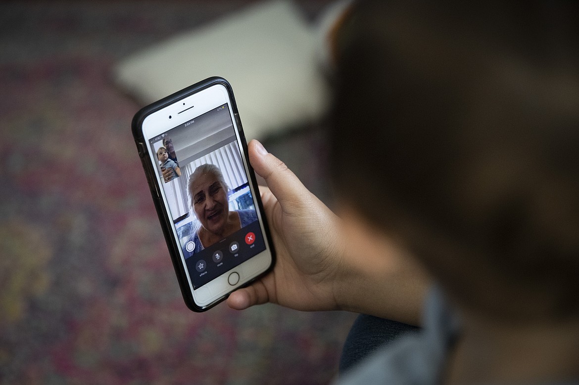 Sarvnaz Michel, a 28-year-old nurse who works in St. Jude Medical Center's COVID-19 unit, video chats with her grandmother, Acar Sharifi, in her home July 14, 2020, in Garden Grove, Calif. Michel's career has forced her to blur and blend her two lives. She juggles decisions like breastfeeding during a pandemic and whether she should move out of her home to keep her son and husband safe. "The thought of infecting either of them or my family," she said. Her voice breaks and her husband, Cody, rubs her back. "It's crazy." (AP Photo/Jae C. Hong)