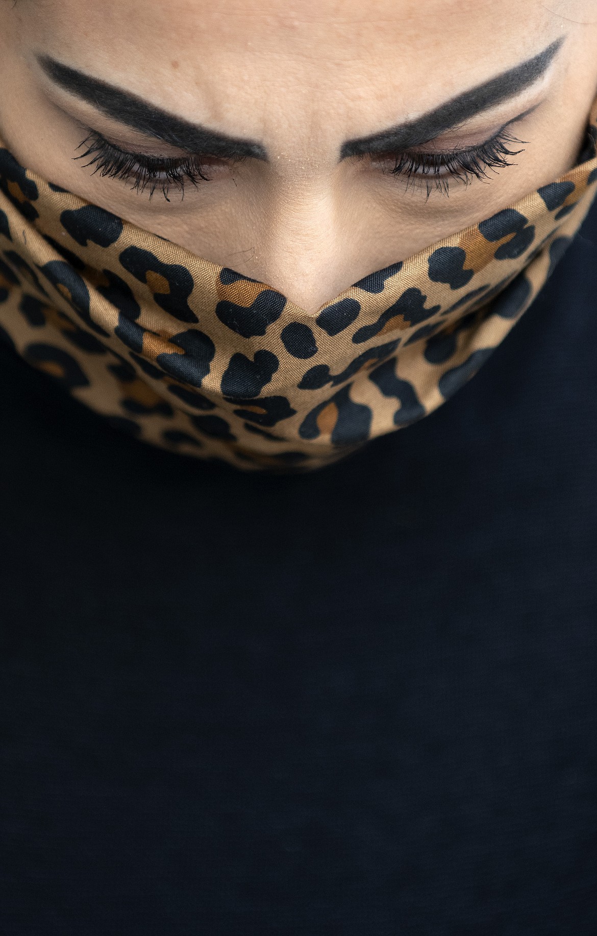 Liyah Babayan, owner of Ooh La La, wears a stylish leopard print mask Monday, April 6, 2020, out front of her store on Main Avenue in Twin Falls, Idaho. The masks are lined to help keep the transmission of particles to a minimum. (Drew Nash/Times-News via AP)