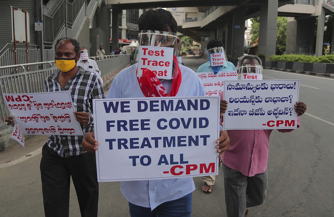 Activists of Communist Party of India Marxist wearing face shields and hold placards during a protest asking the state government to increase testing and free treatment for all COVID-19 patients in Hyderabad, India, Monday, June 29, 2020. Governments are stepping up testing and warily considering their next moves as the number of newly confirmed coronavirus cases surges in many countries. India reported more than 20,000 new infections on Monday.  (AP Photo/Mahesh Kumar A.)