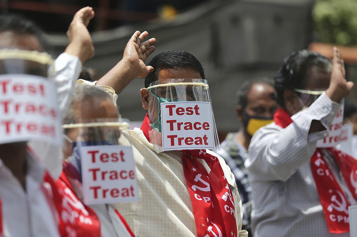 Activists of Communist Party of India Marxist display placards on face shields and shout slogans during a protest asking the state government to increase testing and free treatment for all COVID-19 patients in Hyderabad, India, Monday, June 29, 2020. Governments are stepping up testing and warily considering their next moves as the number of newly confirmed coronavirus cases surges in many countries. India reported more than 20,000 new infections on Monday. (AP Photo/Mahesh Kumar A.)