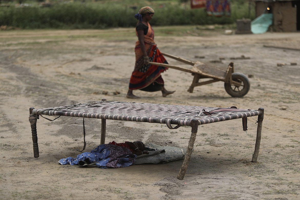 An Indian woman works at a brick kiln as her child sleeps under a cot during lockdown to curb the spread of new coronavirus on the outskirts of Jammu, India, Sunday, May 10, 2020. India's lockdown entered a sixth week on Sunday, though some restrictions have been eased for self-employed people unable to access government support to return to work. (AP Photo/Channi Anand)