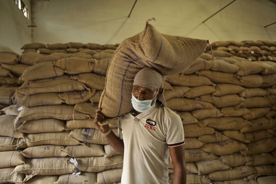 An Indian laborer carries a rice bag after they were unloaded from trains to store at at Food Corporation of India (FCI) warehouse during lockdown in Jammu, India, Thursday, April 16, 2020. Indian Prime Minister Narendra Modi on Tuesday extended the world's largest coronavirus lockdown to head off the epidemic's peak, with officials racing to make up for lost time. (AP Photo/Channi Anand)