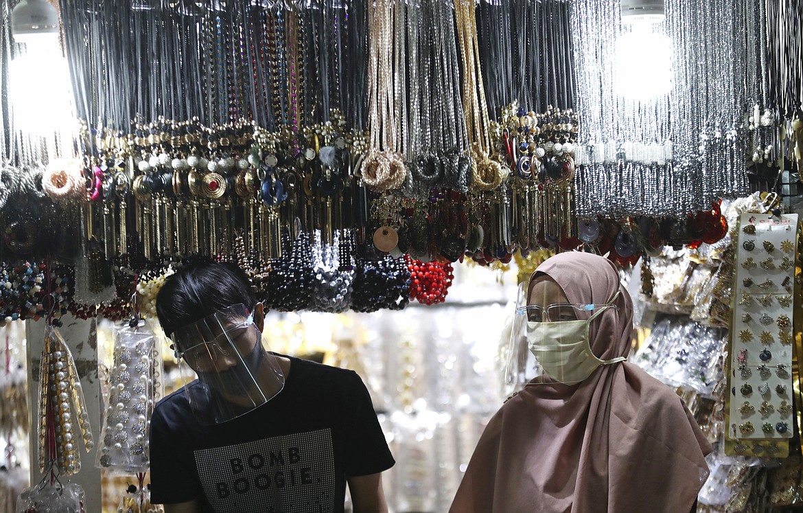 Accessories venders wearing face mask wait customers amid fears of the new coronavirus outbreak at a market in Jakarta, Indonesia Tuesday, June 30, 2020.(AP Photo/Achmad Ibrahim)