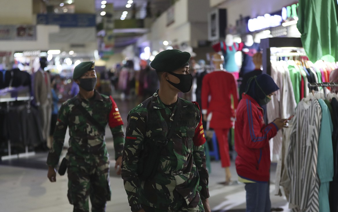 Indonesian soldiers wearing face mask patrol amid fears of the new coronavirus outbreak at a market in Jakarta, Indonesia Tuesday, June 30, 2020.(AP Photo/Achmad Ibrahim)