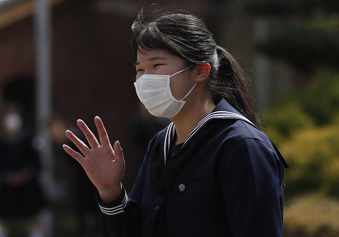 Japan's Princess Aiko, daughter of Emperor Naruhito and Empress Masako, wearing a protective face mask following an outbreak of the coronavirus disease (COVID-19), waves to well-wishers as she attends her graduation ceremony at Gakushuin Girls' Senior High School in Tokyo, Sunday, March 22, 2020. (Issei Kato/Pool Photo via AP)