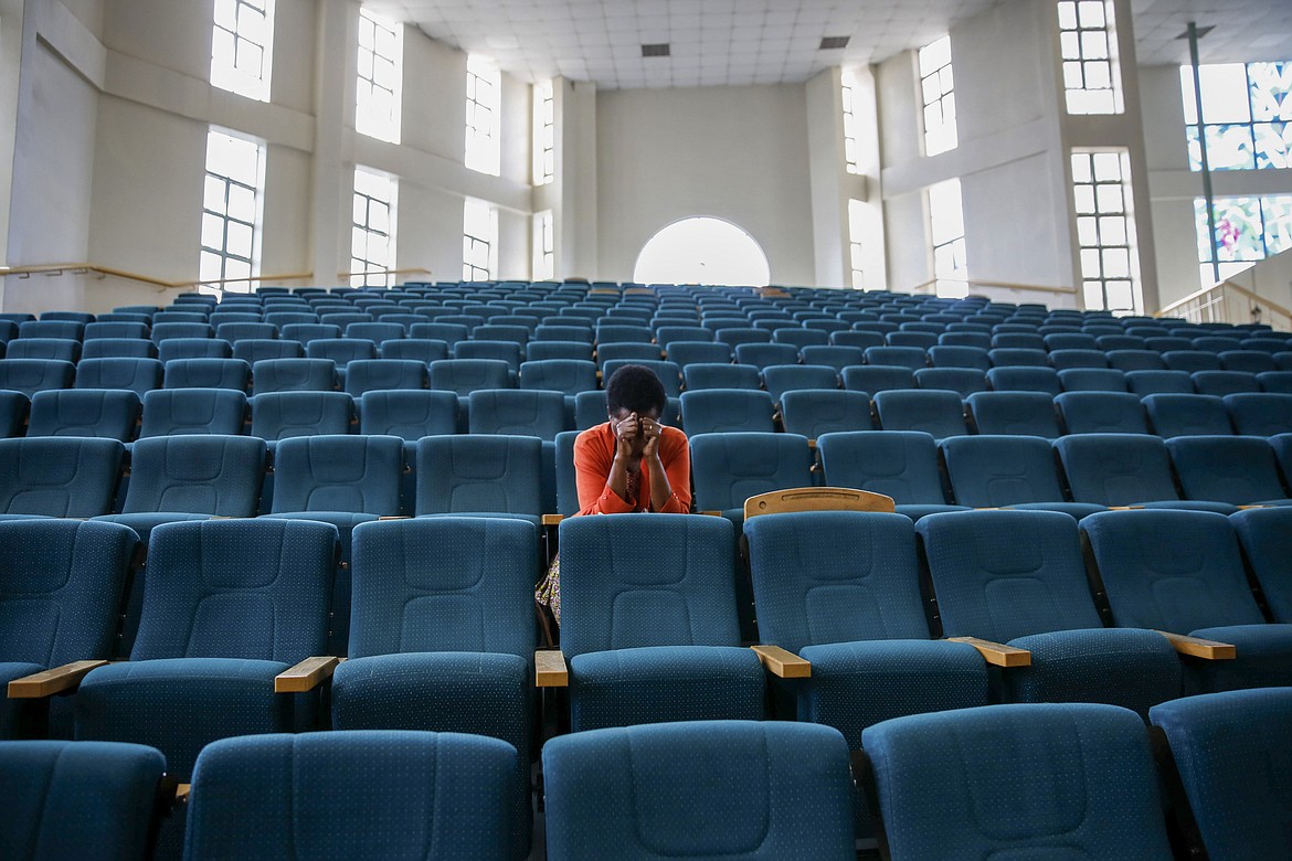 A woman attends a Sunday mass service at the Nairobi Baptist Church, which was streamed live on the internet with almost no attendees in order to limit the spread of the new coronavirus, in the capital Nairobi, Kenya Sunday, March 22, 2020. In Kenya, the Ministry of Health has banned all public gatherings and meetings in order to limit the spread of the new coronavirus that causes COVID-19 but has permitted normal church services to continue so long as they provide hand sanitizing or washing facilities to attendees. (AP Photo/Brian Inganga)