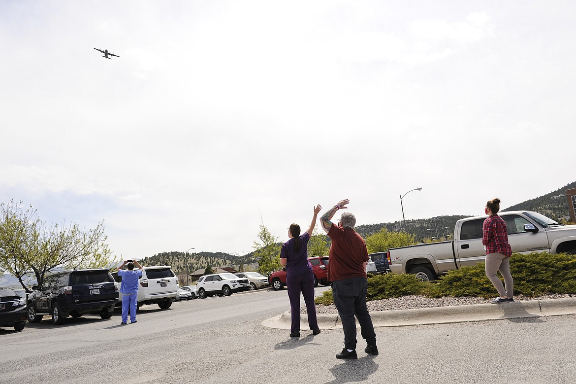 St. Peter's Health staff and nurses wave to a Montana Air National Guard C-130 as it flies over St. Peter's Health in Helena, Mont. Wednesday, May 6, 2020. The flight, which spanned most of western Montana, was conducted to show support to health care workers on the front lines of the COVID-19 pandemic. (Thom Bridge/Independent Record via AP)