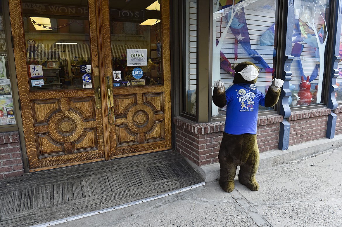 A PPE-clad stuffed bear greets patrons at the Lasso the Moon toy store Monday, April 27, 2020, in Helena, Mont. (Thom Bridge/Independent Record via AP)