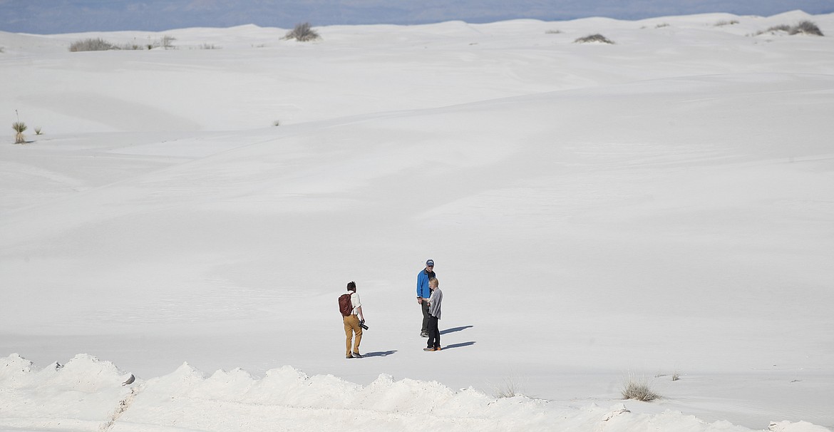 In this March 5, 2020, photograph, visitors climb a gypsum dune in White Sands National Park at Holloman Air Force Base, N.M. Most national parks are open as a refuge for Americans tired of being stuck at home because of the coronavirus. Entry fees have been eliminated, but many parks are closing visitor centers, shuttles and lodges to fight the spread of the virus. (AP Photo/David Zalubowski)(AP Photo/David Zalubowski)