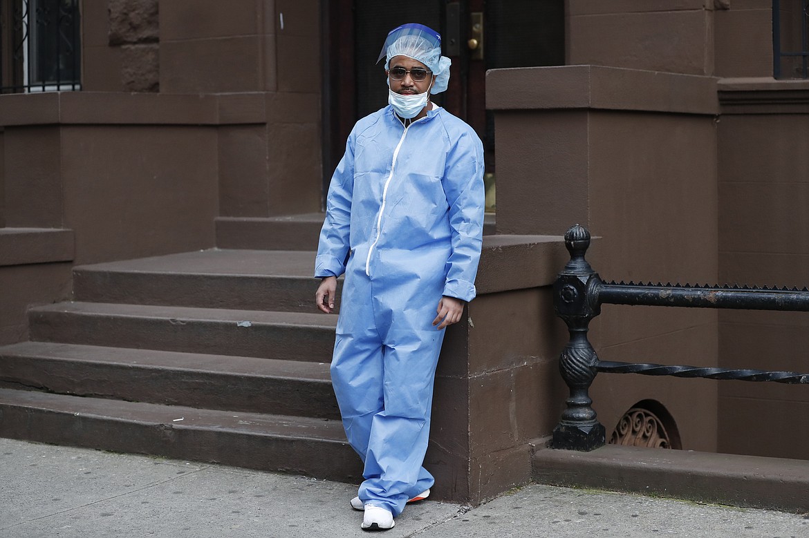 Wearing his personal protective equipment, emergency room nurse Brian Stephen leans against a nearby stoop as he takes a break from his work at the Brooklyn Hospital Center, Sunday, April 5, 2020, in New York. Located in downtown Brooklyn, the hospital is one of several in the New York area that has been treating high numbers of coronavirus patients during the current viral pandemic. (AP Photo/Kathy Willens)