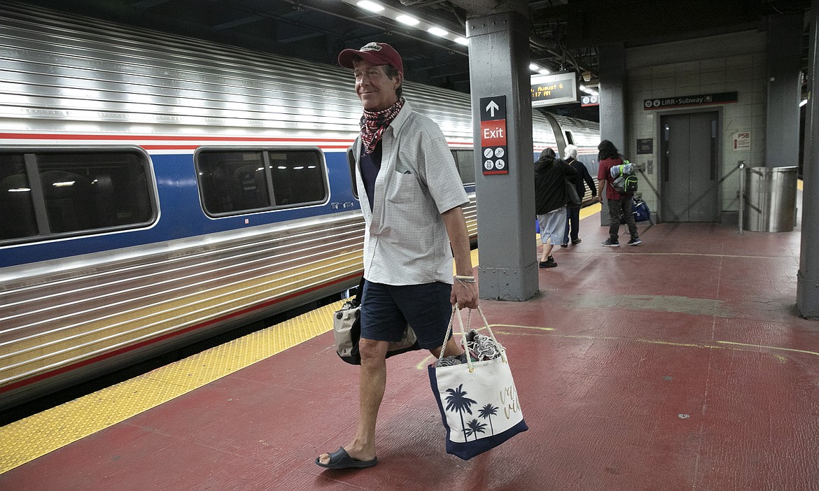 Timothy Mahyna arrives on a train from Georgia at Amtrak's Penn Station, Thursday, Aug. 6, 2020, in New York. Mayor de Blasio is asking travelers from 34 states, including Georgia where COVID-19 infection rates are high, to quarantine for 14 days after arriving in the city. Mahyna, from Syracuse, N.Y., said, "I will probably quarantine for a week when I get home." (AP Photo/Mark Lennihan)