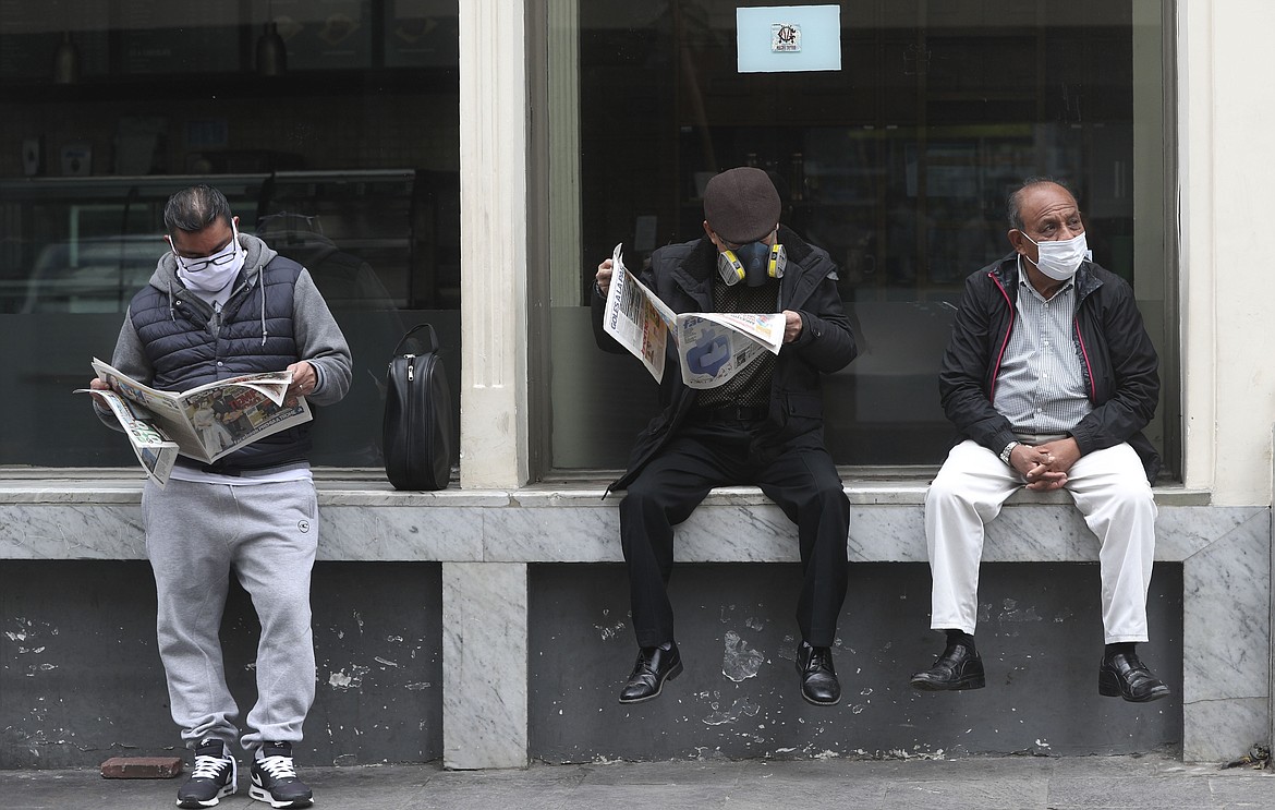 People wearing masks to curb the spread of the new coronavirus wait for businesses to open in downtown Lima, Peru, Wednesday, July 1, 2020. (AP Photo/Martin Mejia)