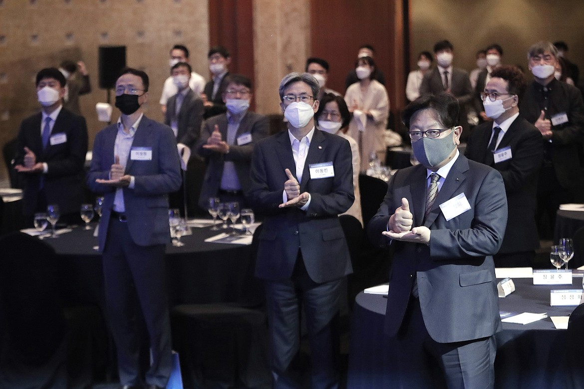 Participants wearing face masks to help protect against the spread of the new coronavirus gesture as they join the "Thank You Challenge" for medical workers fighting the coronavirus during the Yonhap News Symposium on Korean Peace in Seoul, South Korea, Tuesday, June 30, 2020. (AP Photo/Ahn Young-joon)