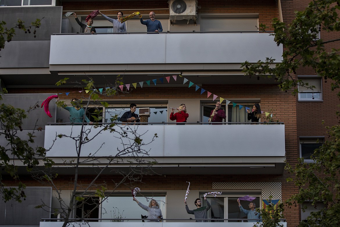 People play instruments as other dance on their balconies in support of the medical staff that are working on the COVID-19 virus outbreak in Barcelona, Spain, Sunday, April 5, 2020. Spanish Prime Minister Pedro Sanchez announced that he would ask the Parliament to extend the state of emergency by two more weeks, taking the lockdown on mobility until April 26. The new coronavirus causes mild or moderate symptoms for most people, but for some, especially older adults and people with existing health problems, it can cause more severe illness or death. (AP Photo/Emilio Morenatti)