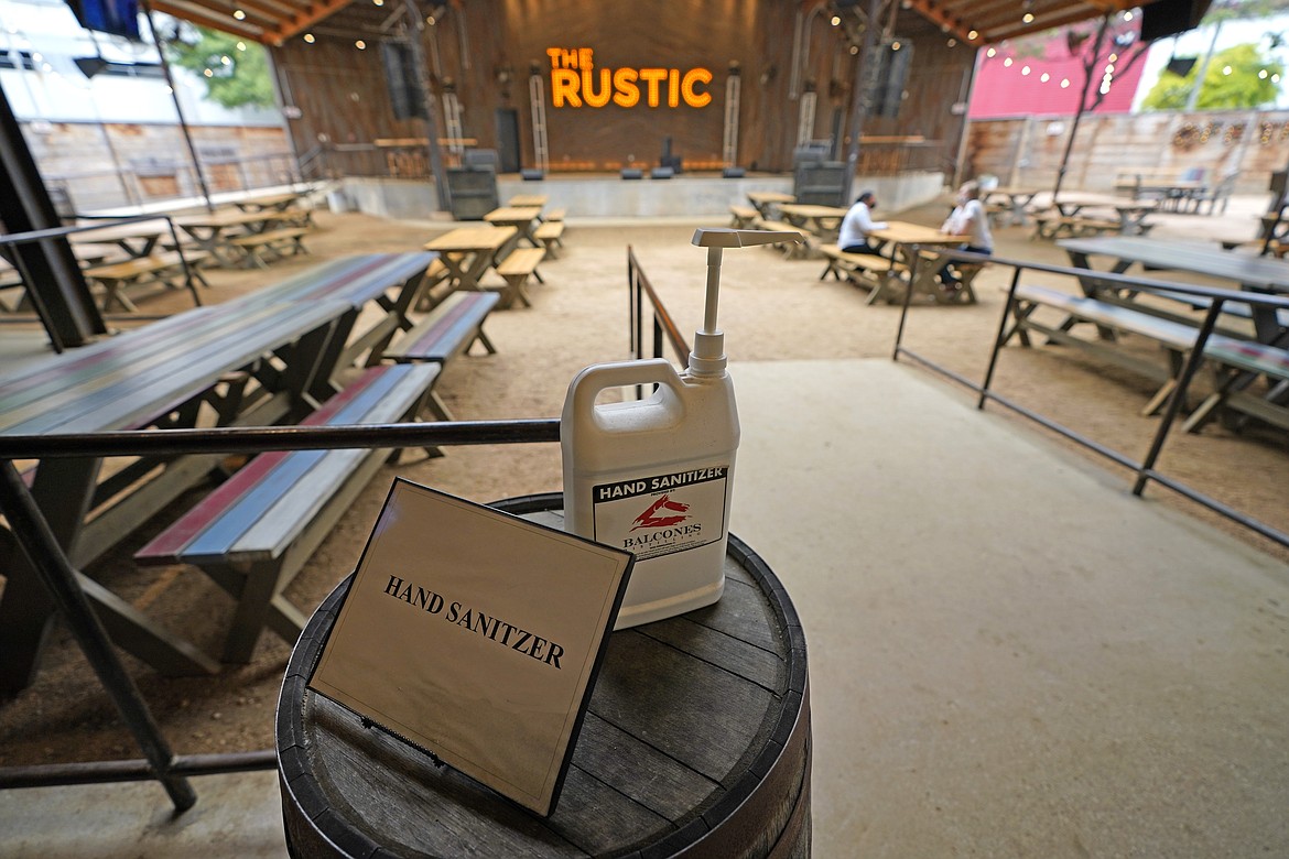A bottle of hand sanitizer is available to customers inside The Rustic Friday, June 26, 2020, in Houston. The restaurant and bar will be limited to 50% capacity after Texas Gov. Greg Abbott announced Friday that he is shutting bars back down and scaling back restaurant capacity to 50%, in response to the increasing number of COVID-19 cases in Texas.(AP Photo/David J. Phillip)