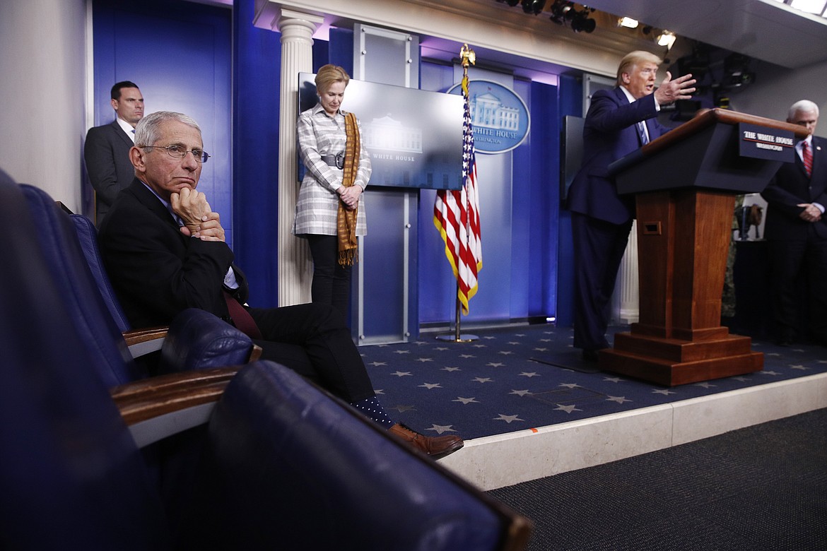 Dr. Anthony Fauci, director of the National Institute of Allergy and Infectious Diseases, left, listens as President Donald Trump speaks during a coronavirus task force briefing at the White House, Sunday, April 5, 2020, in Washington. From left, Fauci, Dr. Deborah Birx, White House coronavirus response coordinator, Trump and Vice President Mike Pence. (AP Photo/Patrick Semansky)