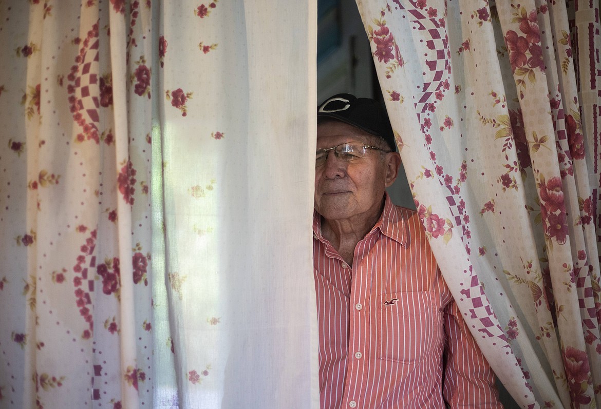 Radio announcer Jose Luis Munoz, 62, looks out from his home in Caracas, Venezuela, Thursday, Aug. 20, 2020, amid the new coronavirus pandemic. Due to the quarantine to curb the spread of COVID-19 since March 16, he can no longer go to his work at a government-run radio station. But instead of staying isolated and silent, he got down to business and it didn't take long to resume his contact with people as an amateur radio announcer from his home. (AP Photo/Ariana Cubillos)