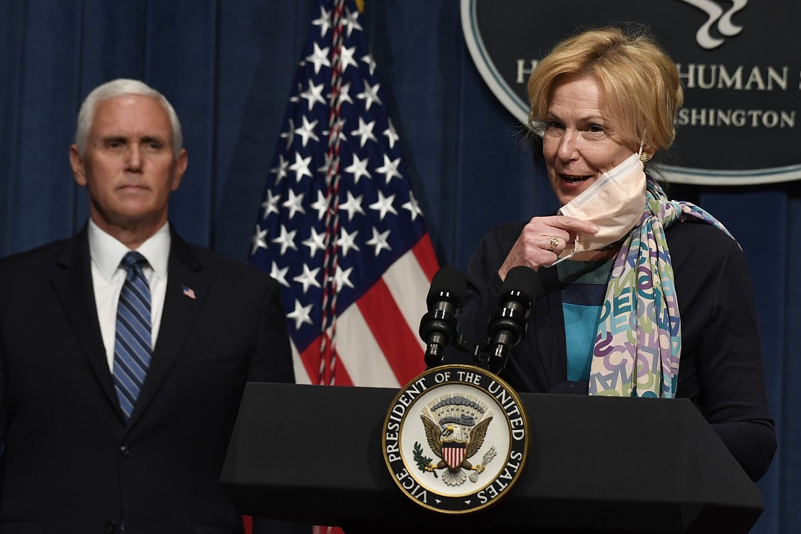 Dr. Deborah Birx, right, takes off her mask as she goes to speak during a news conference with members of the Coronavirus Task Force at the Department of Health and Human Services in Washington, Friday, June 26, 2020. Vice President Mike Pence listens at left. (AP Photo/Susan Walsh)