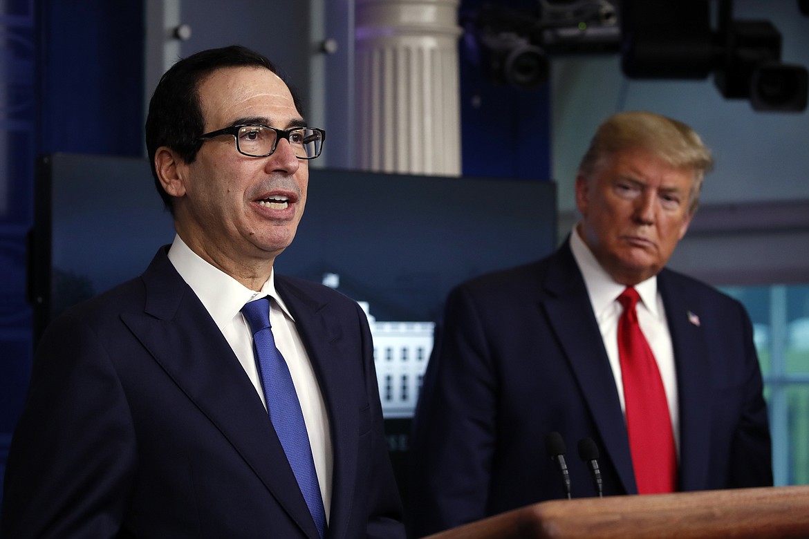 FILE - In this April 13, 2020, file photo President Donald Trump listens as Treasury Secretary Steven Mnuchin speaks about the coronavirus in the James Brady Press Briefing Room at the White House in Washington. The Trump administration and Congress are nearing an agreement as early as Sunday, April 19, on a $400-plus billion aid package to boost a small-business loan program that has run out of money and add funds for hospitals and COVID-19 testing.  (AP Photo/Alex Brandon, File)