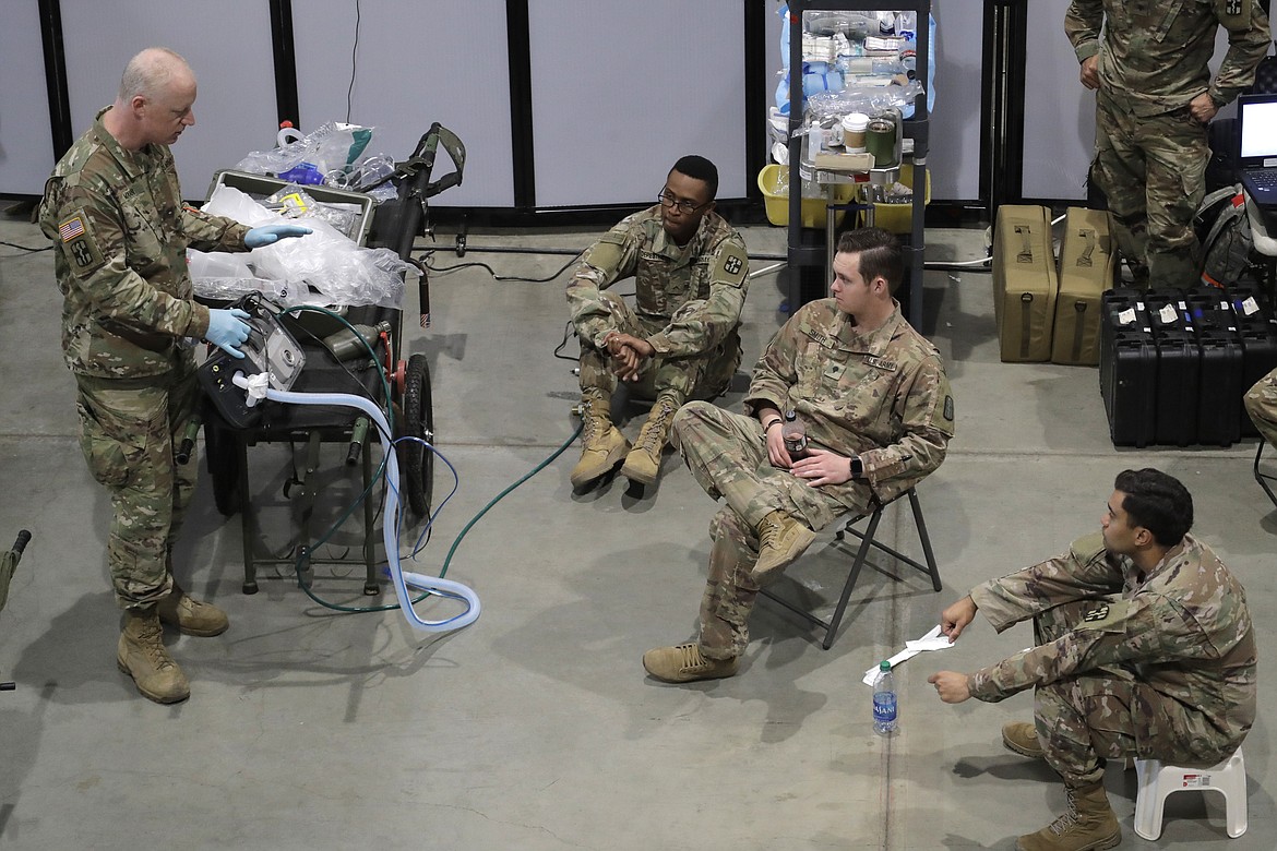 Soldiers take part in a ventilator training session at the site of a military field hospital, Sunday, April 5, 2020, at the CenturyLink Field Event Center in Seattle. Officials said the facility, which will be used for people with medical issues that are not related to the coronavirus outbreak, has more than 200 beds and is ready to receive patients. (AP Photo/Ted S. Warren)