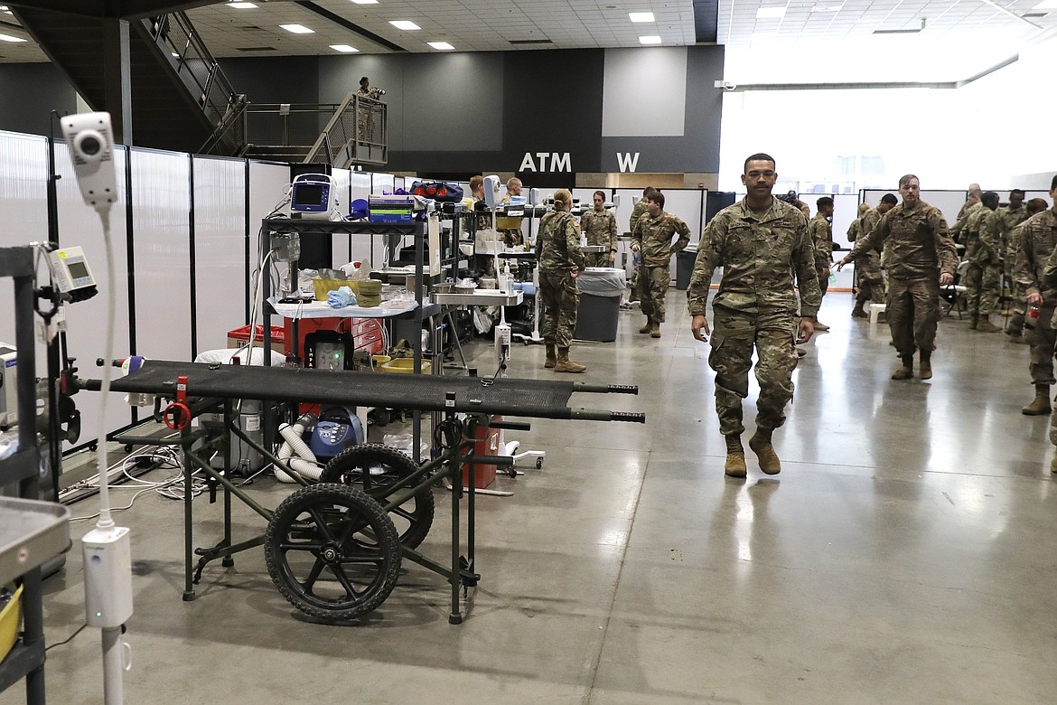 Soldiers walk through a treatment area following a training session at the site of a military field hospital, Sunday, April 5, 2020, at the CenturyLink Field Event Center in Seattle. Officials said the facility, which will be used for people with medical issues that are not related to the coronavirus outbreak, has more than 200 beds and is ready to receive patients. (AP Photo/Ted S. Warren)
