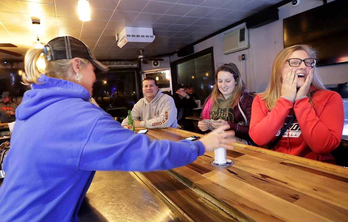 Owner Abbie Quella serves a birthday drink to Elizabeth Hietpas at Club Ritz following the Wisconsin Supreme Court's decision to strike down Gov. Tony Evers' safer-at-home order amid the coronavirus pandemic, Wednesday, May 13, 2020, in Kaukauna, Wis. (William Glasheen/The Post-Crescent via AP)