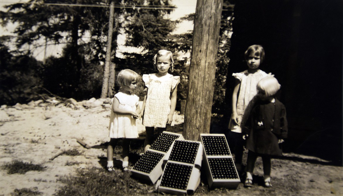 Friends of the Bowman family pose near row-packed specialty boxes of cherries in this undated photo. (Photo provided)