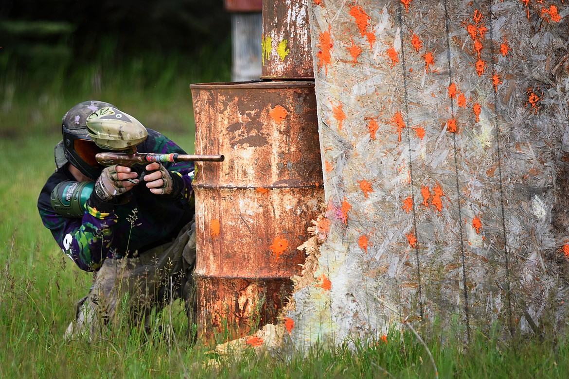 Charles “Flint” Campbell seeks safety behind an empty barrel as he launches his shots at the enemy. (Jeremy Weber/Daily Inter Lake)