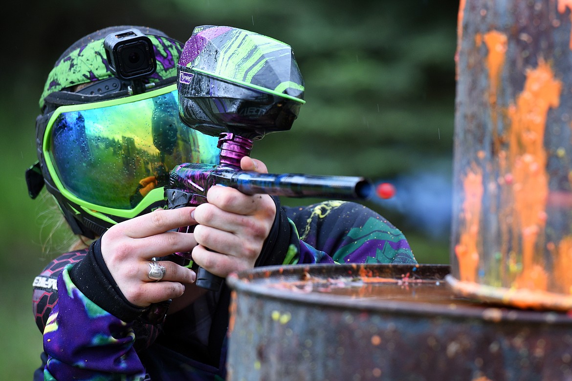 Montana Action Paintball owner Nicholas Lynn launches a shot at his foes from behind a stack of barrels. (Jeremy Weber/Daily Inter Lake)