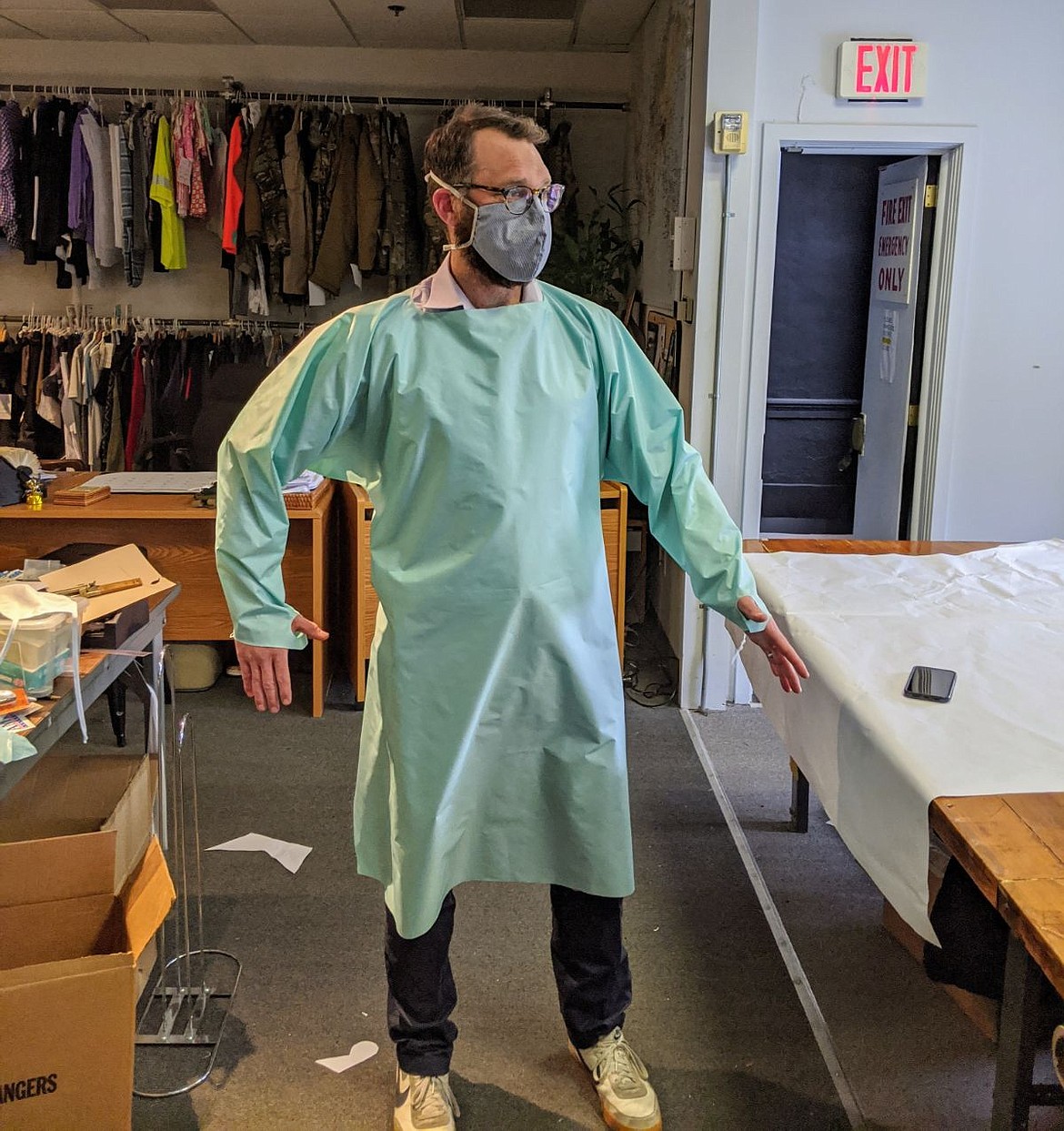 An employee at a FORLOH facility tries on a medical mask and gown made by the outdoor apparel company.