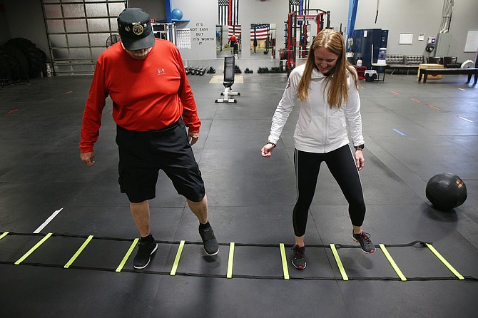 Trainer Lauren Ketner helps Navy veteran Chalie Till, 70, with mobility exercises, Sept 24, 2018 at the Andrew's Strength and Performance (ASAP) gym in Coeur d'Alene. (LOREN BENOIT/Press)