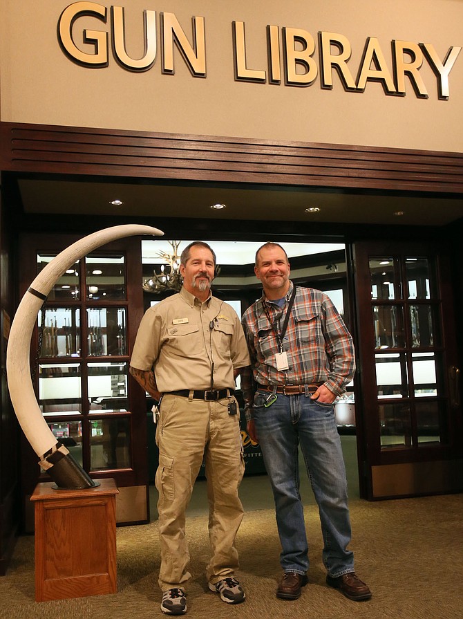 Cabela’s general manager Randy Longnecker, right, said retired U.S. Army staff sergeant David Sanftner, left, has been a quick learner at Cabela’s. Sanftner became an outfitter in the gun library at Cabela’s in Post Falls this fall.