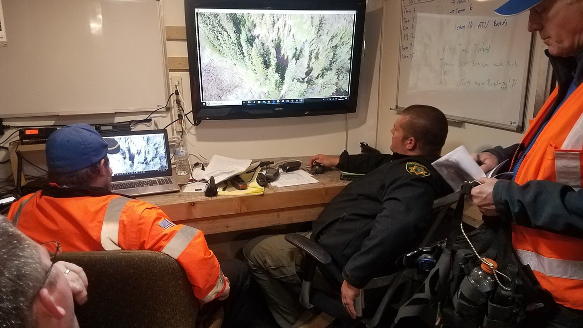 Silver Valley SAR and KCSO SAR personnel review drone footage in SV-SAR's trailer this weekend.