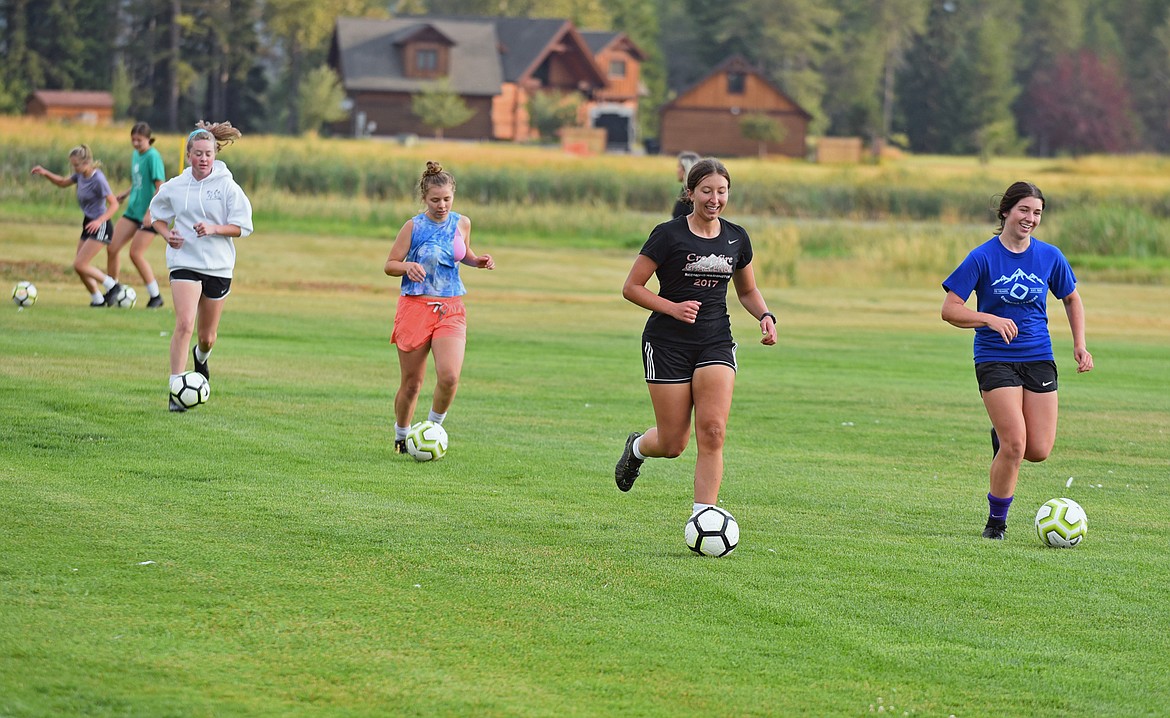 Players on the Whitefish girls soccer team dribble the ball around the field during a fit test at practice on Aug. 20 at Smith Fields. (Whitney England/Whitefish Pilot)