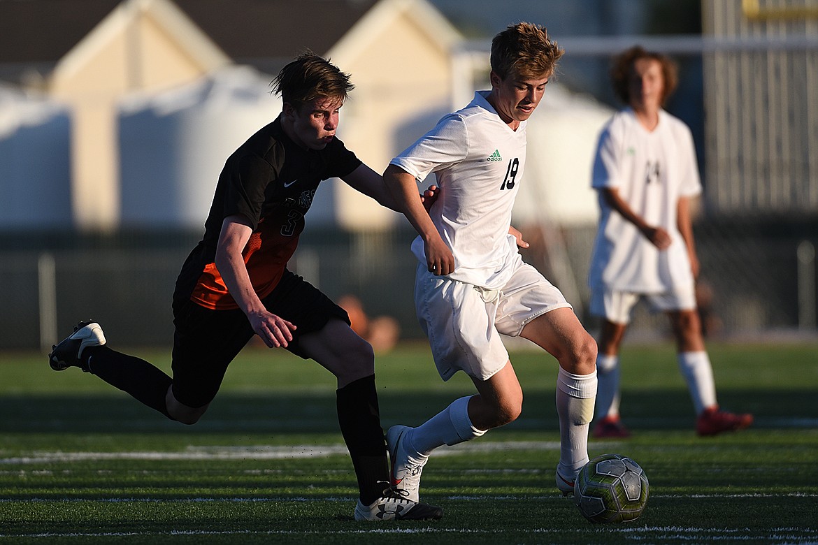 Glacier’s Harrison Sanders (19) and Flathead’s Kian Tanner (3) battle for possession during crosstown soccer at Legends Stadium on Thursday. (Casey Kreider/Daily Inter Lake)