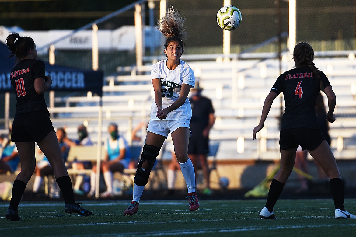 Glacier’s Taylor Brisendine (23) heads a ball upfield between Flathead defenders Ashlynn Whiteman (10) and Kami Darrow (4) during crosstown soccer at Legends Stadium on Thursday. (Casey Kreider/Daily Inter Lake)