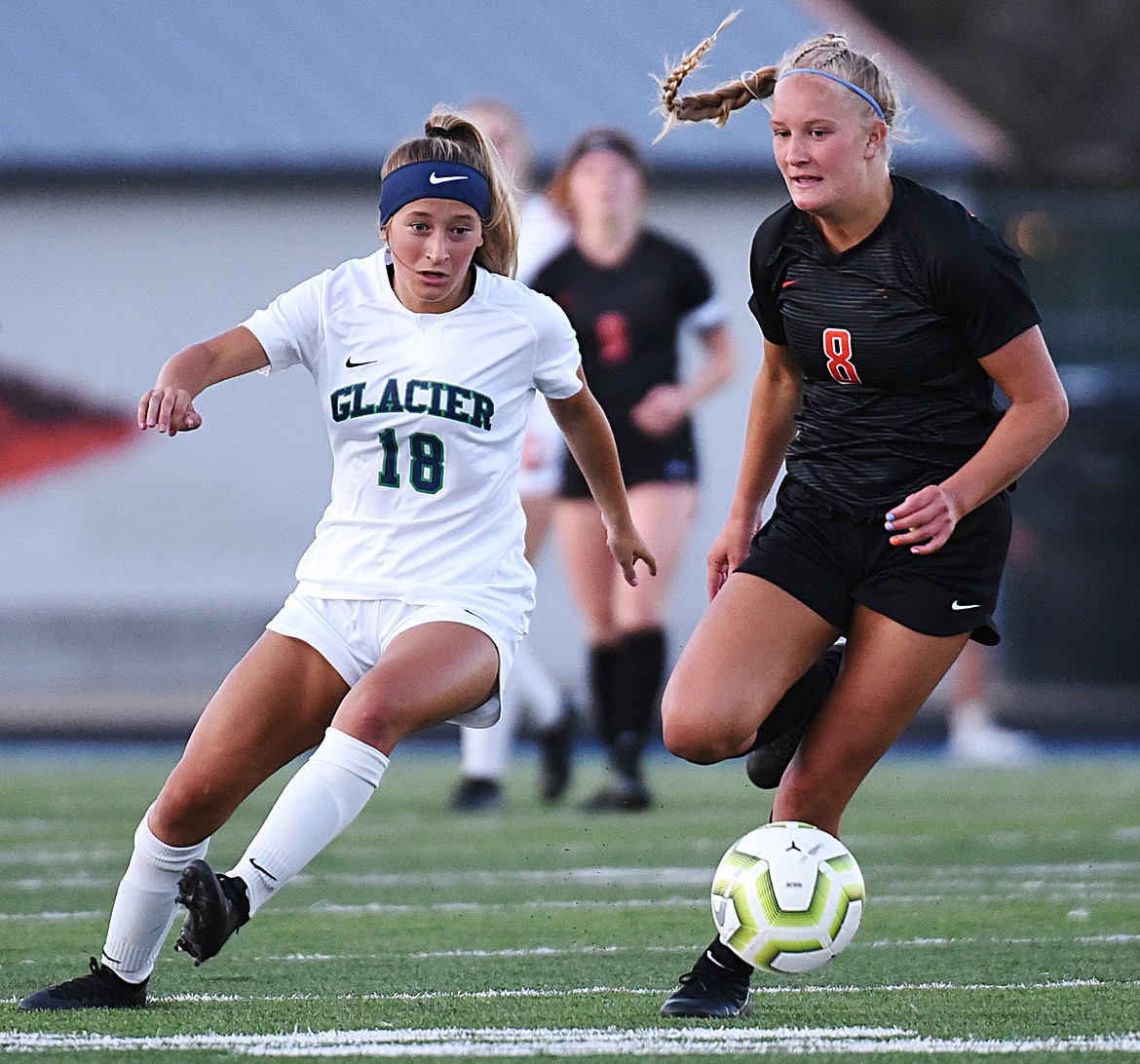 Glacier’s Madison Becker (18) and Flathead’s Chloe Mohatt (8) battle for possession during crosstown soccer at Legends Stadium on Thursday. (Casey Kreider/Daily Inter Lake)